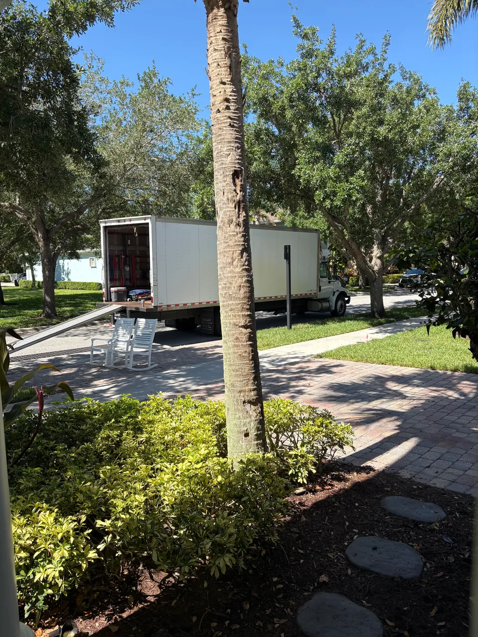 Andersen Moving box truck on a tree-lined Jensen Beach street